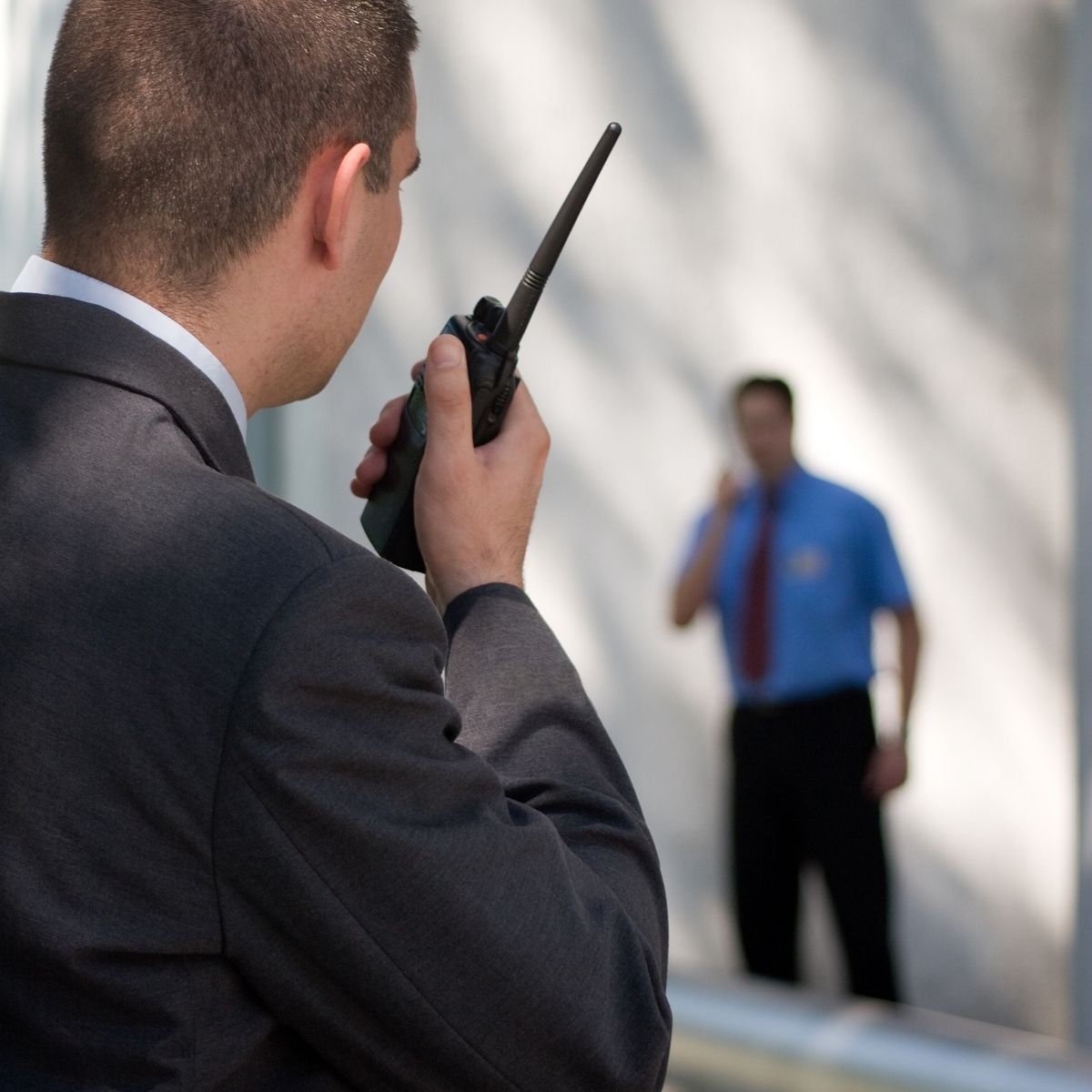 Agent de sécurité ajustant son équipement lors d'une patrouille en centre-ville. Agent de sécurité privé en uniforme ajustant son équipement lors d’une intervention en milieu urbain.